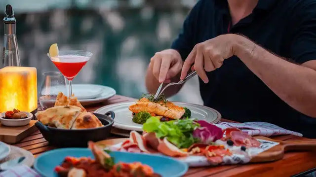 Một bộ bàn ăn được bày với cocktail, món hải sản và các loại trang trí đầy màu sắc.