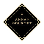 Logo hình kim cương màu đen với văn bản vàng đọc là 'ANNAM GOURMET' và một ngôi sao làm điểm nhấn.