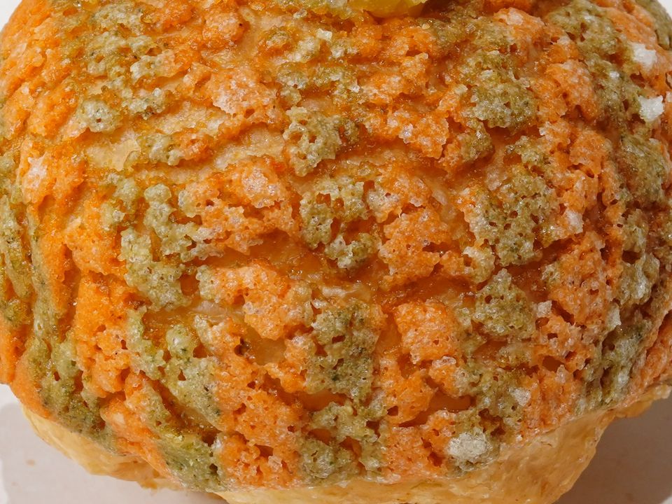 Melon Bloom, cận cảnh lớp vỏ giòn · Melon Bloom, close-up of an orange and green crackled crust