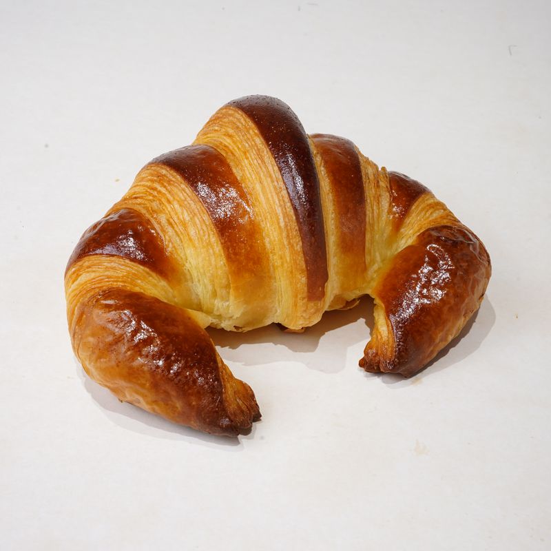 Croissant · Bánh croissant cong hình lưỡi liềm, vỏ nâu bóng · Crescent croissant with a glossy brown crust